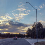 An Astrophile Series street light by a highway as the sun sets